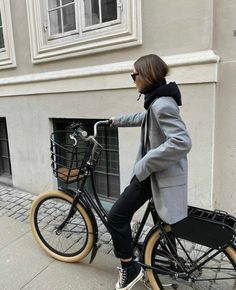 a woman riding on the back of a bike