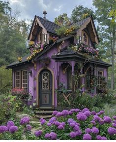 a purple house with lots of flowers around it