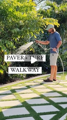 a man using a garden hose to spray water