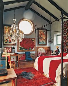 a bedroom with a bed, chandelier and pictures on the wall