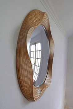 a mirror mounted to the side of a white wall next to a window with shutters