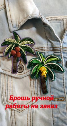 a pair of palm trees are in the pocket of a jean jacket that is decorated with beads and sequins