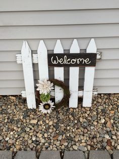 a white picket fence with a welcome sign