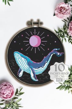 the cross stitch pattern shows a blue whale in front of pink flowers