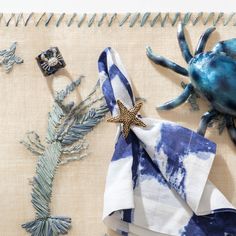 blue and white napkins with starfish, pine branches and other items on top