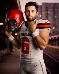 a man in a football uniform holding a helmet