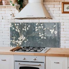 a stove top oven sitting inside of a kitchen next to a white brick wall with flowers on it