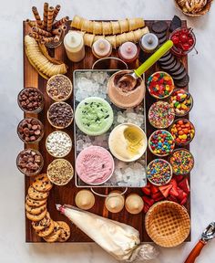 an assortment of desserts and pastries are arranged on a wooden tray with ice cream