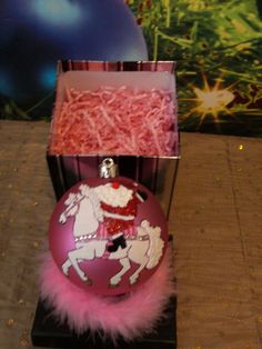 a pink ornament sitting on top of a table next to a purple ball