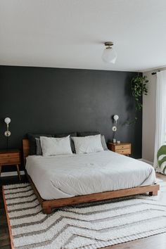 a bedroom with a bed, nightstands and rug