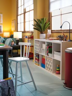 a room filled with lots of furniture next to a table and two chairs in front of a window