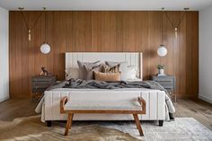 a bedroom with wood paneling and white bedding, along with two nightstands