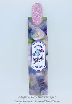 a bookmark with a bird on it and a pink heart hanging from the top