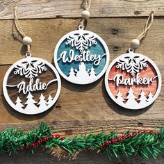 three christmas ornaments hanging on a wooden wall