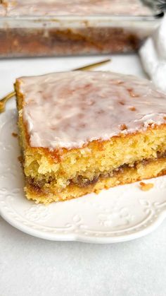 a piece of cake sitting on top of a white plate next to a glass pan