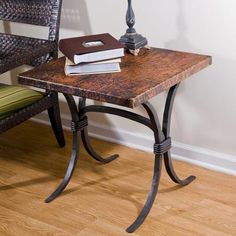 a table with two books on it next to a wicker chair and floor lamp