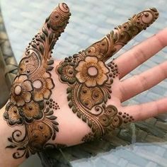 the hand is decorated with henna and flowers