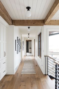 a long hallway with wooden floors and white walls