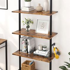 three shelves with books, vases and pictures on them in the corner of a room