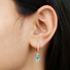 Product Details Experience the perfect combination of simplicity and beauty with this exquisite Aquamarine Huggie Earring. The hoop is adorned with sparkling Brilliant Round Moissanite stones, encasing them in a mesmerizing display of elegance. Hanging gracefully from the hoop is a captivating Oval Shape Aquamarine, adding a touch of vibrant allure to the earring. Product Information SKU SHP-EARRINGS112116910 Length 22.1 mm Width 5.8 mm Height 12 mm Weight 3.00 gm (Approximate) AQUAMARINE INFORM Oval Halo Design Hoop Earrings As Gift, Oval Hoop Earrings With Halo Design For Gift, Hoop Drop Earrings, Huggie Earring, Signature Jewelry, Round Moissanite, Timeless Jewelry, Conflict Free Diamonds, Huggies Earrings