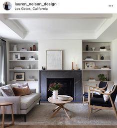 a living room filled with furniture and a fire place in front of a fireplace covered in bookshelves