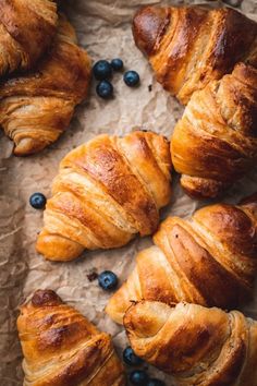 croissants and blueberries are laid out on wax paper, ready to be eaten