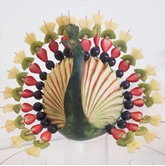 an arrangement of fruits and vegetables arranged into a peacock