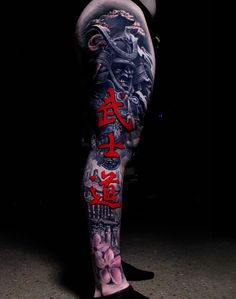 a man with tattoos on his legs and leggings is standing in the dark