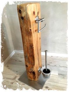 there is a toilet in the shape of a wooden pole with a metal holder on it