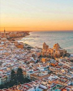 an aerial view of the city and ocean at sunset