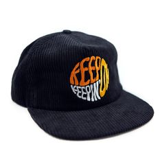 Our "Keep On Keepin' On" slogan goes psychedelic in this 70s-inspired black corduroy cap! Orange, gold and cream embroidery is stitched onto our signature corduroy baseball-style adjustable hat. This version is made to fit a little deeper than our other unstructured hats, which allows it to fit bigger heads. (No giant dome on your head!) Hat has an inside circumference of roughly 23-23.5 inches, but lots of flexibility with the snapback closure. If you love our corduroy caps, check out the Rambl Retro Corduroy Hat For Streetwear, Adjustable Corduroy Trucker Hat For Streetwear, Retro Corduroy Snapback Baseball Cap, Retro Corduroy Snapback Hat, Retro Adjustable Corduroy Baseball Cap, Vintage Adjustable Corduroy Trucker Hat, Wolf Hat, Keep On Keepin On, Cream Embroidery