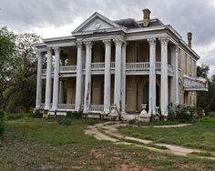 an old abandoned house with columns and pillars