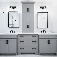 a bathroom with double sinks and two mirrors