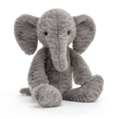 an elephant stuffed animal sitting in front of a white background and looking at the camera