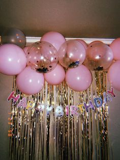 a bunch of balloons and streamers hanging from the ceiling with happy birthday written on them