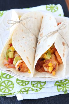 two tacos with shrimp, avocado and corn on them