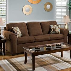 a living room scene with focus on the couch and coffee table in front of the window