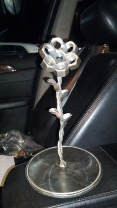 a metal flower sitting on top of a seat in a car