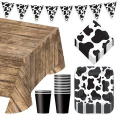 a cow themed party with black and white paper plates, cups, and napkins