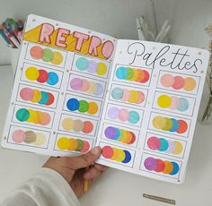 a person holding up a book that has different colored circles on it and the words retro spelled in large letters