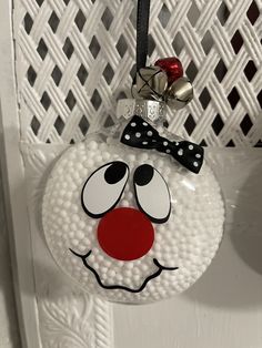 a glass ornament with a red nose and bow