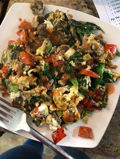 a white plate topped with eggs and vegetables