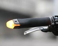 an orange light is on the handlebars of a bicycle's handle bar