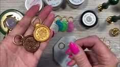 a person holding a ring in their hand next to some other items on the table