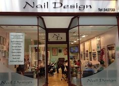 a nail salon with people sitting in the front window and on the side of the building