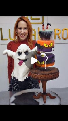 a woman standing next to a halloween cake