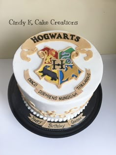 a harry potter birthday cake with hogwart's crest and name on the top