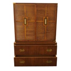 a wooden cabinet with two doors and drawers on the bottom, in front of a white background