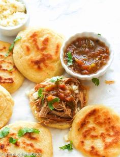 pulled pork on pita bread with salsa and cauliflower in small bowls next to it