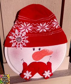 a red and white snowman hat sitting on top of a wooden chair